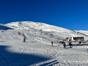 a group of people on a snow covered ski slope at Appartement Saint Lary Soulan Pla d Adet pied des pistes capacité 5pers in Saint-Lary-Soulan