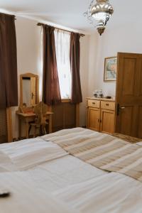 um quarto com uma cama, um espelho e uma janela em Fronius Boutique Residence em Sighişoara