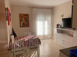 a living room with a dining room table and a kitchen at Casa Montgò in L'Escala