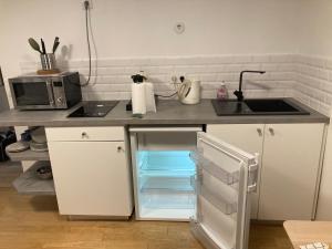 a kitchen with a sink and an open refrigerator at Arts & Métiers Nord Marais Studio 27m2 in Paris