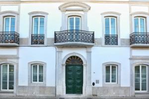 una facciata di un edificio bianco con una porta verde di Hot Breeze Apartment a Faro