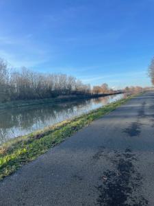 una carretera junto a un río al lado de una carretera en La petite halte en Godshuis