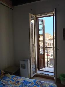 um quarto com uma janela com vista para uma varanda em Guest House Beati Paoli em Palermo