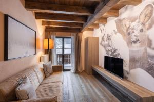 a living room with a couch and a deer on the wall at Cima Dodici B&B - Apartments in Sesto