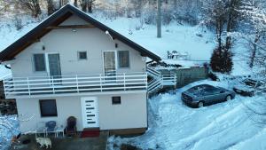 een huis met een auto in de sneeuw bij Vila Vlasina in Vlasina Rid