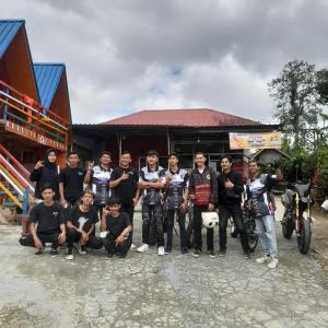 a group of men posing for a picture in front of a building at Homestay Subarda Kamar Natural in Solok