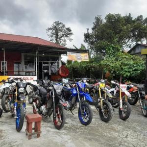 eine Reihe von Motorrädern, die vor einem Gebäude geparkt sind in der Unterkunft Homestay Subarda Kamar Natural in Solok