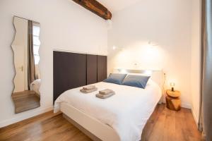 een slaapkamer met een groot wit bed en een spiegel bij Le Laurencin Sens - Le cocon in Sens