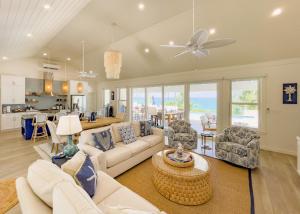 a living room with a white couch and chairs at Pineapple House home in Governorʼs Harbour