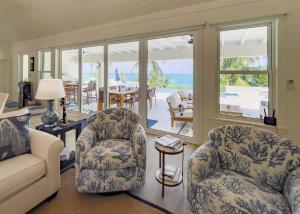 a living room with a couch and chairs and a patio at Pineapple House home in Governorʼs Harbour