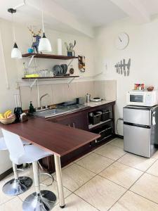 a kitchen with a wooden table and a microwave at Estudio tipo loft Céntrico y Acogedor in San Pedro
