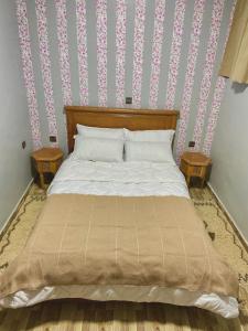 a bedroom with a bed with two end tables at Anza SurfSide House in Agadir