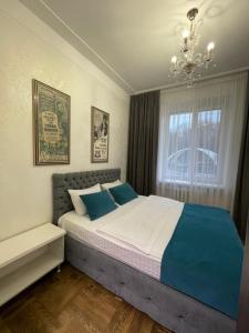 um quarto com uma cama grande e almofadas azuis em Apartment on Soborna 101 em Vinnytsya