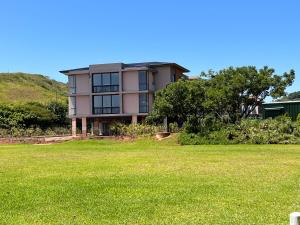 una casa grande en lo alto de un campo de hierba en Zimbali Boulevard Suites 159 en Ballito
