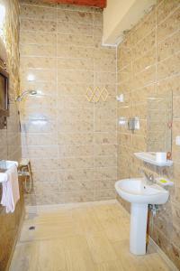 a bathroom with a sink and a shower at Tebtunis in ‘Izbat an Nāmūs