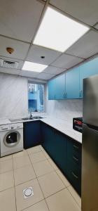 a large kitchen with blue cabinets and a sink at A Perfect Escape - Dubai Marina in Dubai