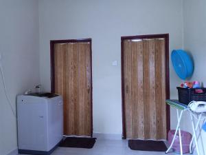 two doors in a room with a refrigerator and a balloon at Tunas Homestay & Chalet in Pantai Cenang