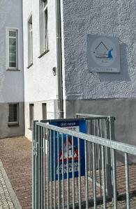 a sign on the side of a building with a fence at Ferienwohnung Gubener Neißeglück 23 in Guben