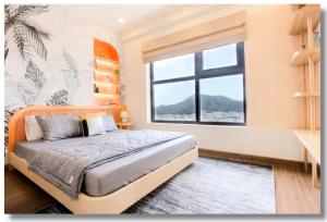 1 dormitorio con 1 cama grande y ventana grande en FLC Sea View Apartment Quy Nhon, en Quy Nhon