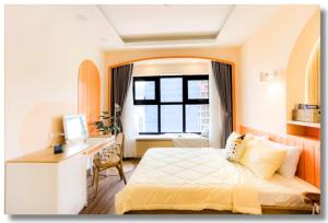 1 dormitorio con cama, escritorio y ventana en FLC Sea View Apartment Quy Nhon, en Quy Nhon
