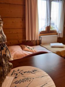 - une chambre avec une table et 2 lits dans l'établissement Pokoje i Apartamenty Regionalny Styl ul Bachledy 41 Zakopane, à Zakopane