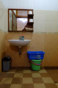 a bathroom with a sink and a trash can at Villa Alicia in Yogyakarta