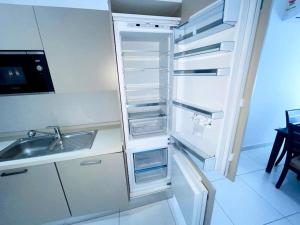 a white refrigerator with its door open next to a sink at Apartment in the heart of Accra. in Accra