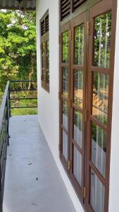 porche con puertas de madera y balcón en Happy Haven Villa, en Weligama