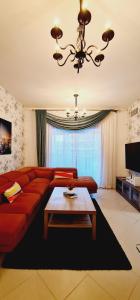 a living room with a red couch and a table at A Perfect Escape - Dubai Marina in Dubai