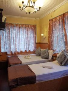 1 Schlafzimmer mit 2 Betten und einem Kronleuchter in der Unterkunft Prime Star Inn in Hongkong