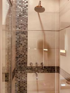 a shower with a glass door and a sink at Aldea Kleinwald in Villa General Belgrano