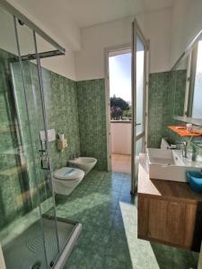 a bathroom with a shower and a toilet and a sink at Hotel Formula Int. & Puravita SPA in Rosolina