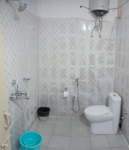 La salle de bains blanche est pourvue d'une douche et de toilettes. dans l'établissement Elegance Delight- Entire 2BHK spacious Flat, à Guwahati