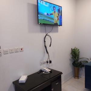 TV de pantalla plana colgada en la pared en لؤلؤ الدرب...ليالي ملكية, en Qarār