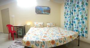 - une chambre avec un lit et une chaise rouge dans l'établissement Elegance Delight- Entire 2BHK spacious Flat, à Guwahati