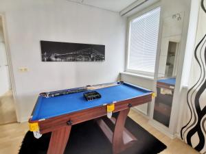 a blue pool table in a room with a wall at City Stay Apartments in Jyväskylä