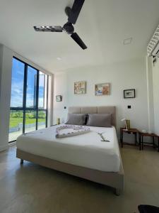 a bedroom with a large bed with a ceiling fan at EQ SURF RETREAT in Muli