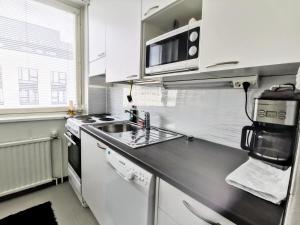 a kitchen with white cabinets and a sink at City Stay Apartments in Jyväskylä