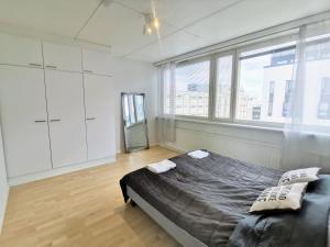 a bedroom with a large bed in a room with windows at City Stay Apartments in Jyväskylä