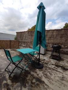 einen Stuhl und einen Regenschirm auf einer Terrasse in der Unterkunft T2 aux portes des Cévennes in Lédignan