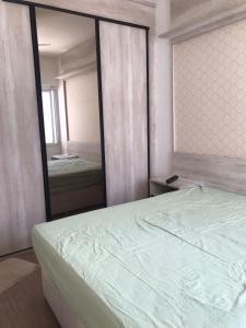 ein Schlafzimmer mit einem Bett und einem großen Spiegel in der Unterkunft Cabo Frio com piscina e excelente localização in Cabo Frio
