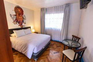 ein Schlafzimmer mit einem Bett, einem Fenster und einem Stuhl in der Unterkunft La Casona de Rimacpampa in Cusco