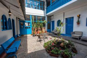 a patio with blue doors and a table and chairs at La Casona de Rimacpampa in Cusco