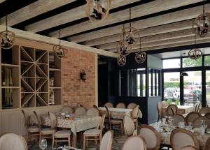 jadalnia ze stołami, krzesłami i oknami w obiekcie Rest Luxury Apartments w Kołobrzegu