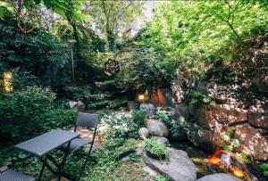 a table and chair in a garden with a waterfall at Hanso Presidential Suite Hanok Hotel in Seoul