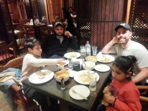 a group of people sitting at a table eating food at H.B Holiday home in Srinagar