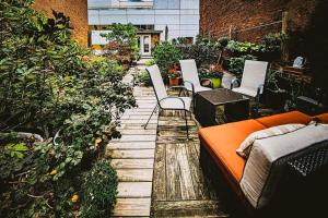 an outdoor patio with an orange couch and chairs at The Historic Lyric Penthouse with Private Rooftop in Cincinnati