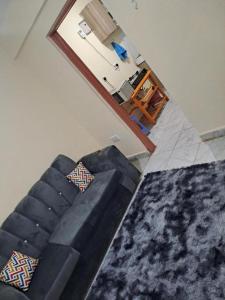 a living room with a black couch and a mirror at Humble homes 1 bedroom Thika Cbd in Thika