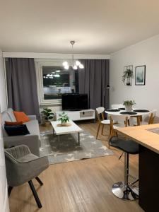 ein Wohnzimmer mit einem Sofa und einem Tisch in der Unterkunft StarHomes 2 BR City Apartment in Kemi