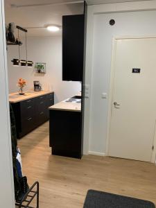 una cocina con armarios negros y una puerta blanca en StarHomes 2 BR City Apartment, en Kemi